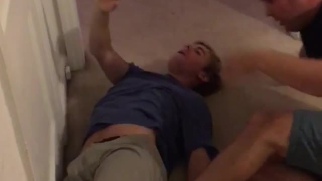 Two guys wrestling in living room one guy gets hurt ow