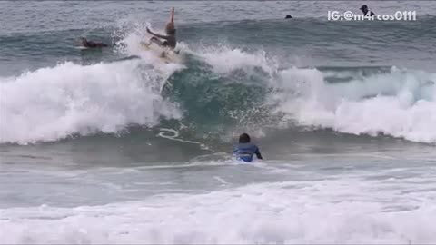 Music surfer turns on wave and goes into other surfer on belly