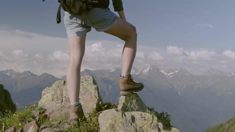 A Person Standing On Rocks A Top A Mountain