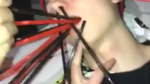 Music friends put red black straws in a sleeping guys mouth