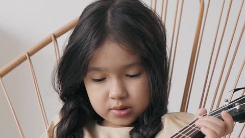 a-girl-fretting-her-ukulele