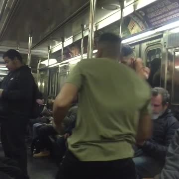 Guy green shirt hanging from subway bars