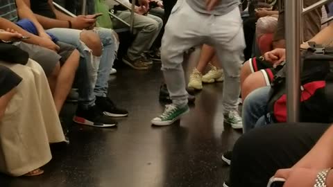 Guy in grey head phones on train dancing