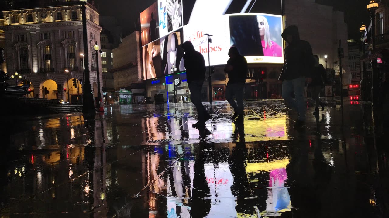 People Walking The Street Of London On A Rainy Night