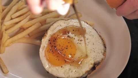 Burger being prepared with french fries