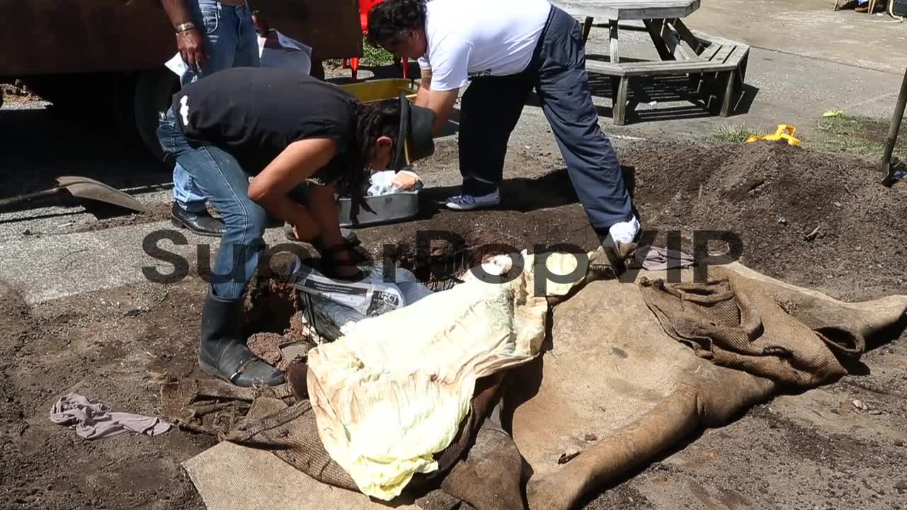 New Zealanders uncover food cooked in a traditional Hangi