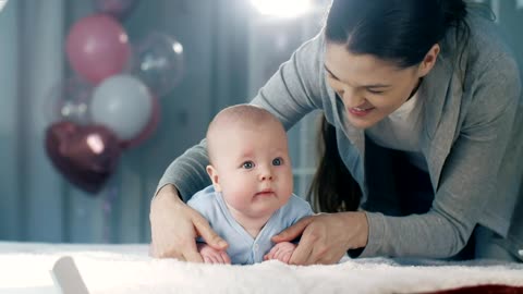 Young mother playing and loving her baby