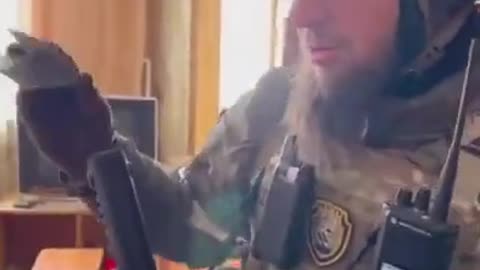 Pro- Russia Chechen fighters check captured Ukranian military ID