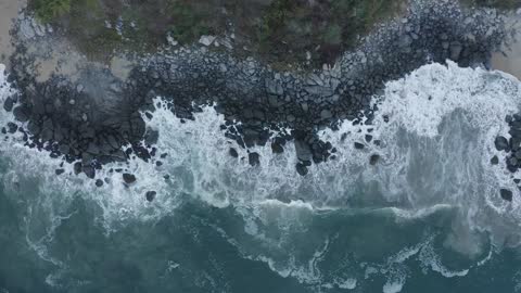 Top aerial shot of seashore with rocks