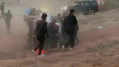 A car rolls over from the top of the sandy hills