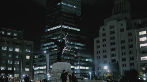 Statue in a city square downtown at night