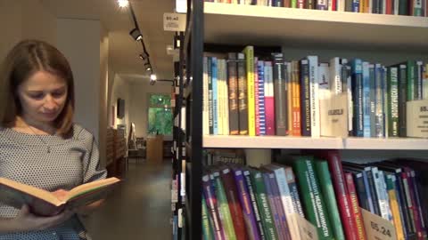 Woman Reading Inside A Library