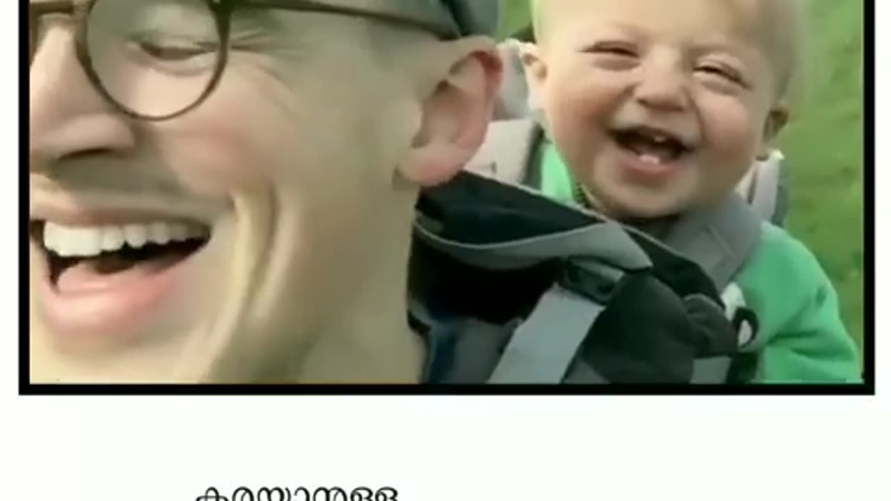 The child is laughing with his father