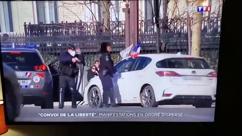 La milice politique en action: Le policier sort son arme et vise le conducteur