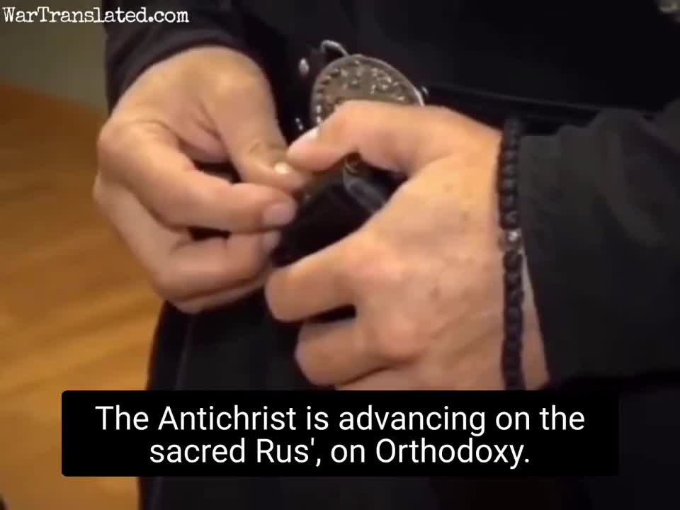 Russian monk teaches how to load ammunition into machine gun