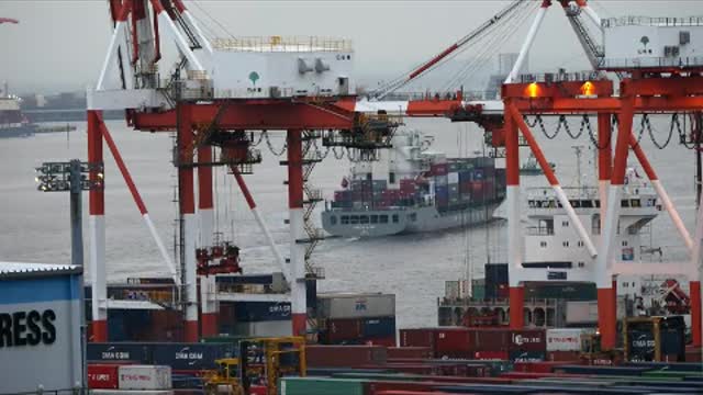 Workers moving containers from a cargo ship