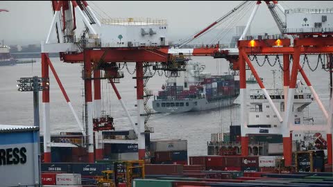 Workers moving containers from a cargo ship