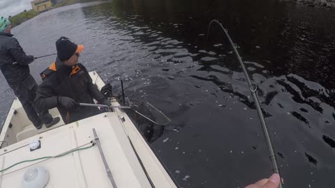 Huge pike strikes the lure just by the boat