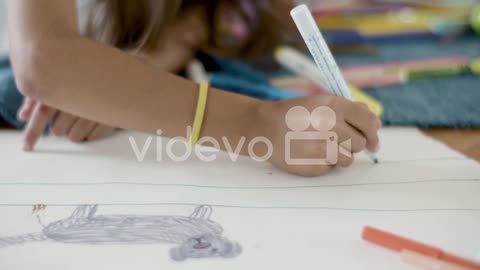 Close Up Shot Of An Unrecognizable Girl Lying On Floor And Drawing Line With Felt Pen On Paper