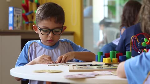 Boy trying to put puzzle together