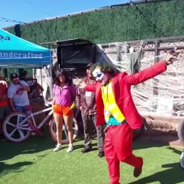 The Joker dances, throws candy to an enthusiastic crowd, and hands out stickers