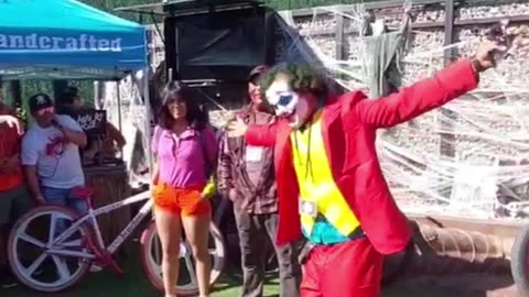 The Joker dances, throws candy to an enthusiastic crowd, and hands out stickers