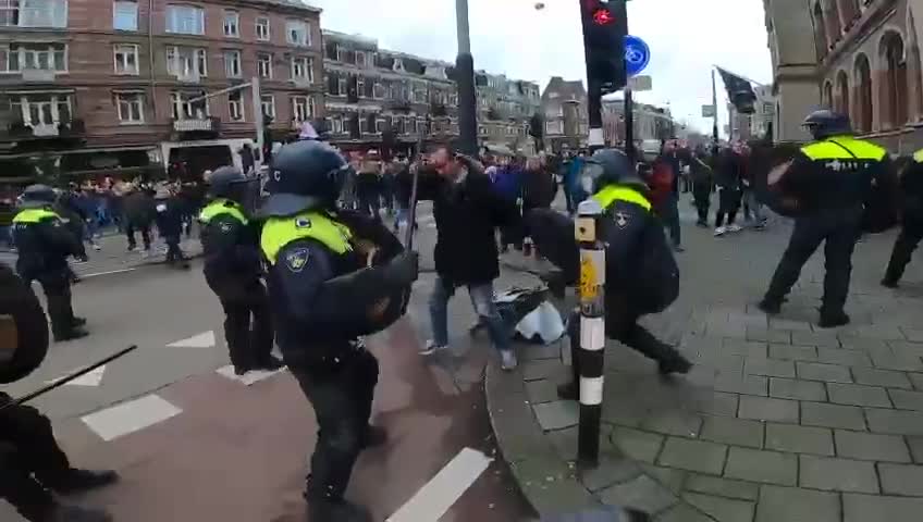 People beaten with batons at unauthorized protest against COVID restrictions in Amsterdam.