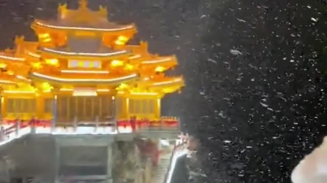 An entry view of a Chinese temple in the mountains during a storm