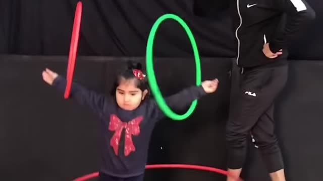 Determined Girl Tries To Teach Her Big Colourful pooch To Hulla Hoop