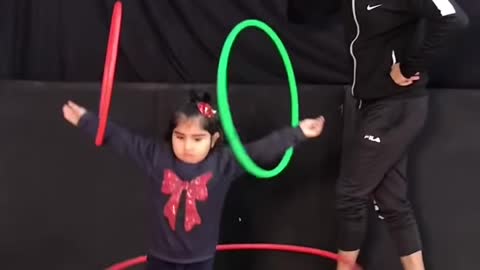 Determined Girl Tries To Teach Her Big Colourful pooch To Hulla Hoop