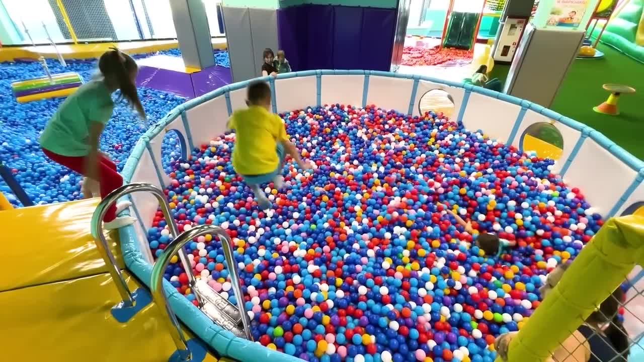 Sofia and a lot of colored balls on the Playground for kids