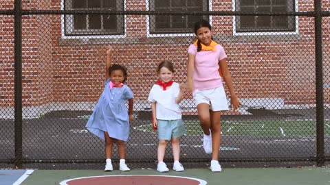 Three Girls Leaning on a Cyclone Wired Fence