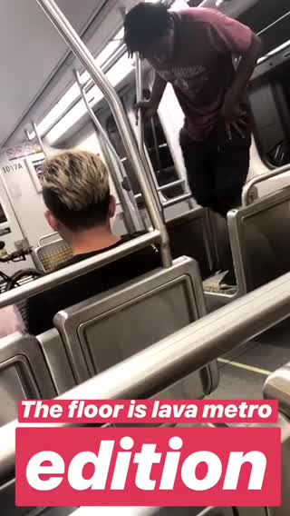 Guy red shirt standing on subway seats