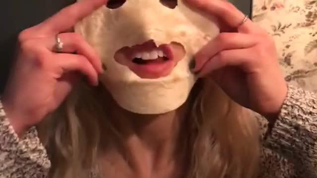 Girl bites eye and mouth holes into tortilla and sticks out tongue