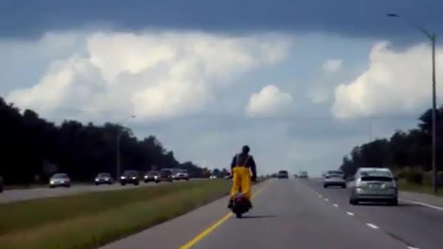 Crazy Guy Standing On Motorcycle On Highway