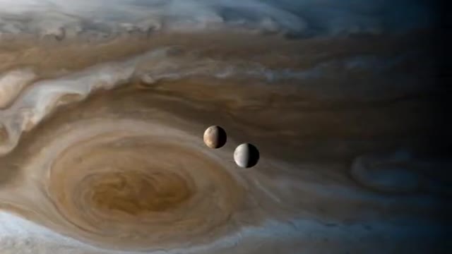 Europa & Io moons orbiting Jupiter, captured by the Cassini space probe