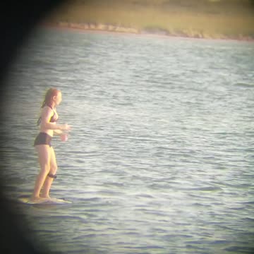 Girl on wake board in black bathing suit almost falls