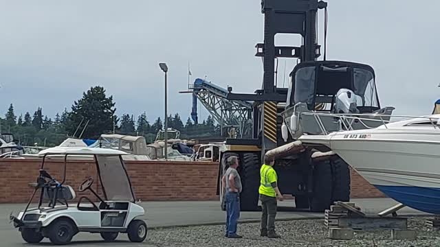 Large Marina Forklift Sets Down a Boat on Dry Dock Pads w/ Fart noise.