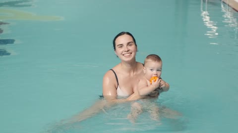 A mother teaches her son to swim when he is young