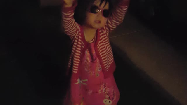 girl wearing sunglasses singing twinkle little star at night