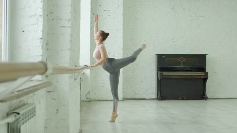 Ballet dancer stretching on a barre
