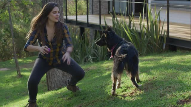 Woman playing ball with a dog