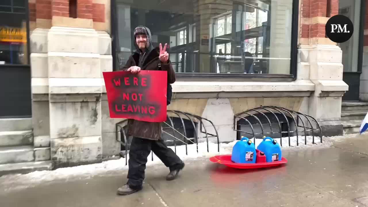 A Freedom Convoy supporter hauls jerrycans on a sled