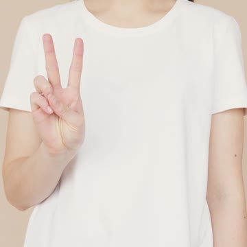 A Woman Wearing White Shirt while Doing Peace Sign