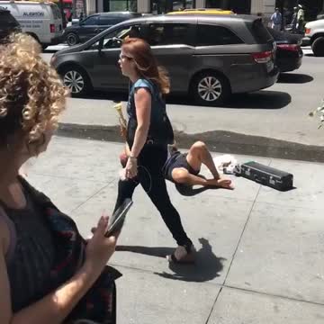 Man in blue laying on his back plays trumpet