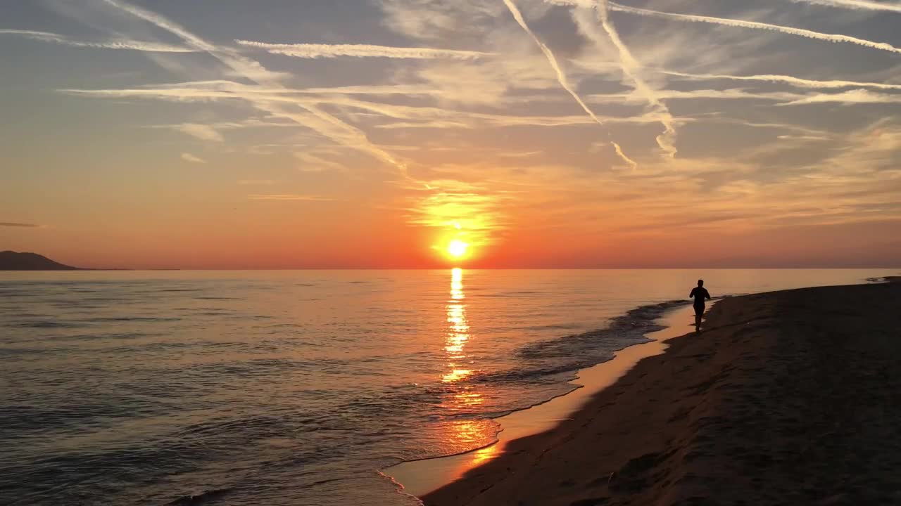 Guy running at the beach during sunset
