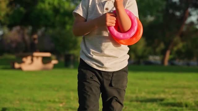 Boy Running In A Field With A Toy Wooden Airplane In His Hands At Sunset