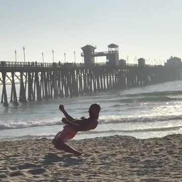 Guy pink shorts at beach doing weird dance