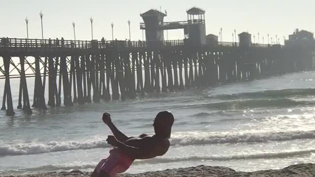 Guy pink shorts at beach doing weird dance