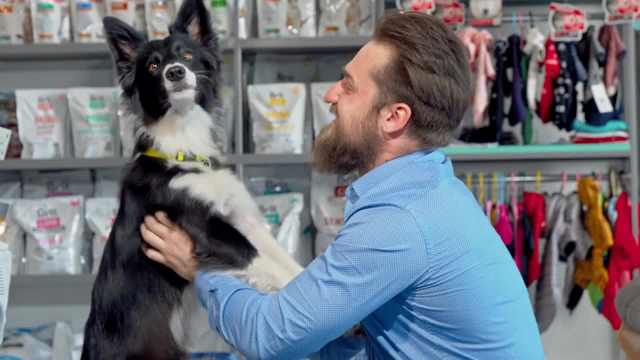 Happy bearded man playing with his dog at veterinarian office